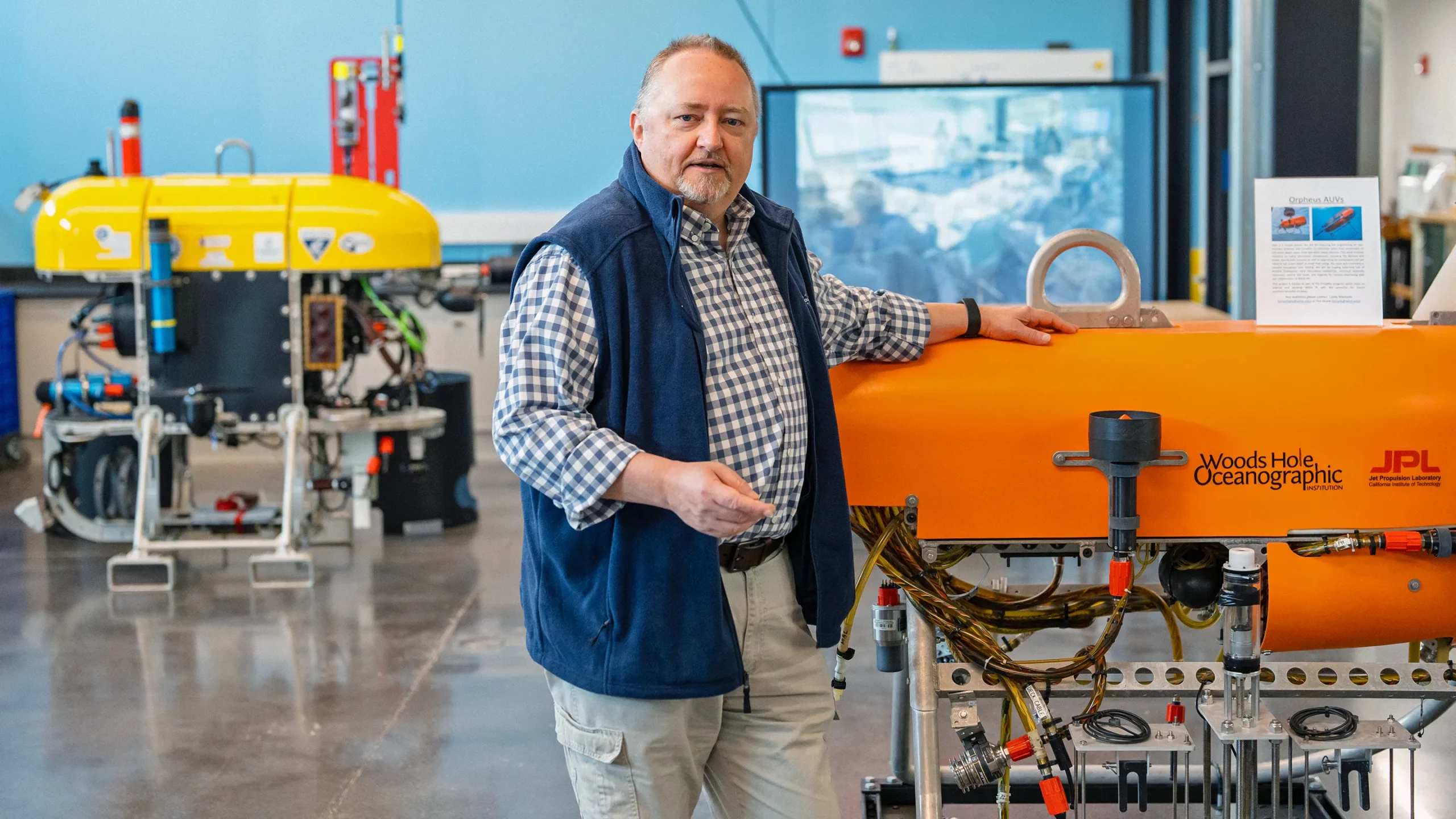 Researcher Chris German standing beside a remotely operated vehicle at the Woods Hole Oceanographic Institute.