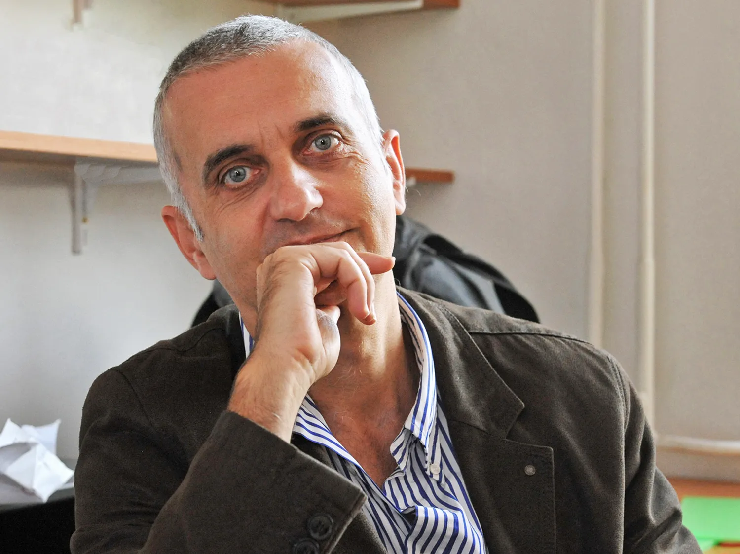 A portrait of Gábor Domokos. He is wearing a striped shirt and he looks thoughtful.