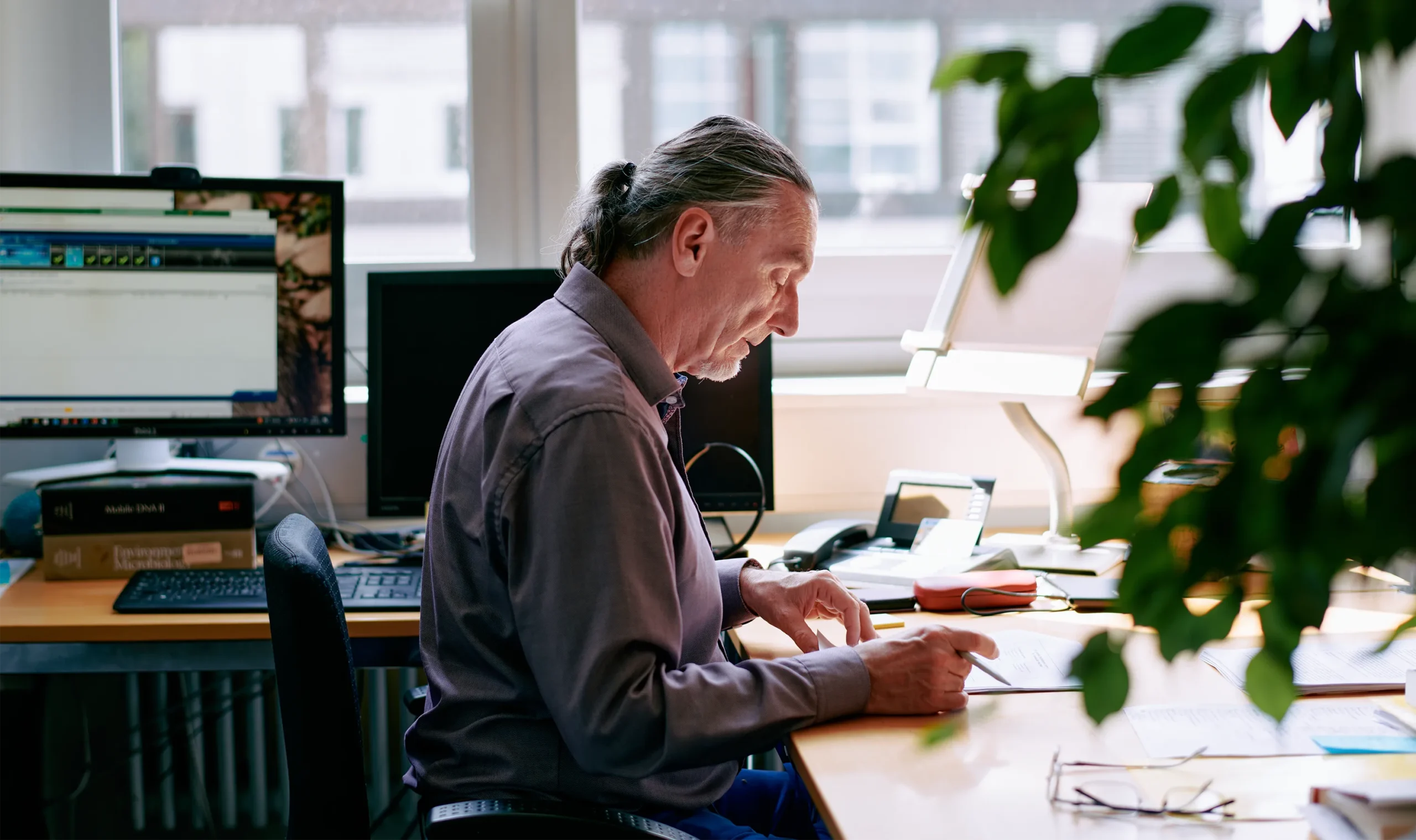 Andreas Wagner looks through documents while seated at his office desk.