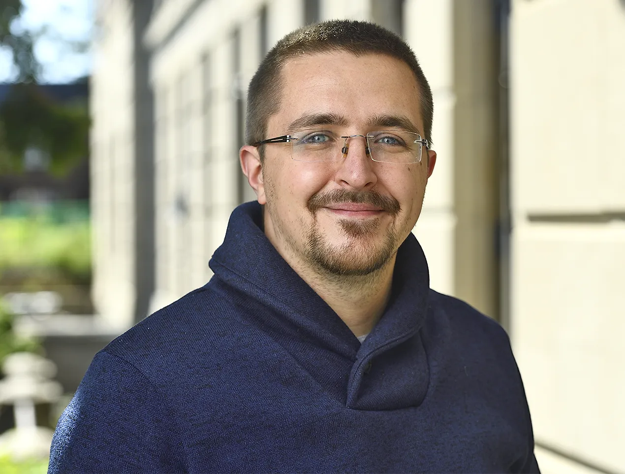 Ben Grimmer in a dark sweatshirt in front of a building.