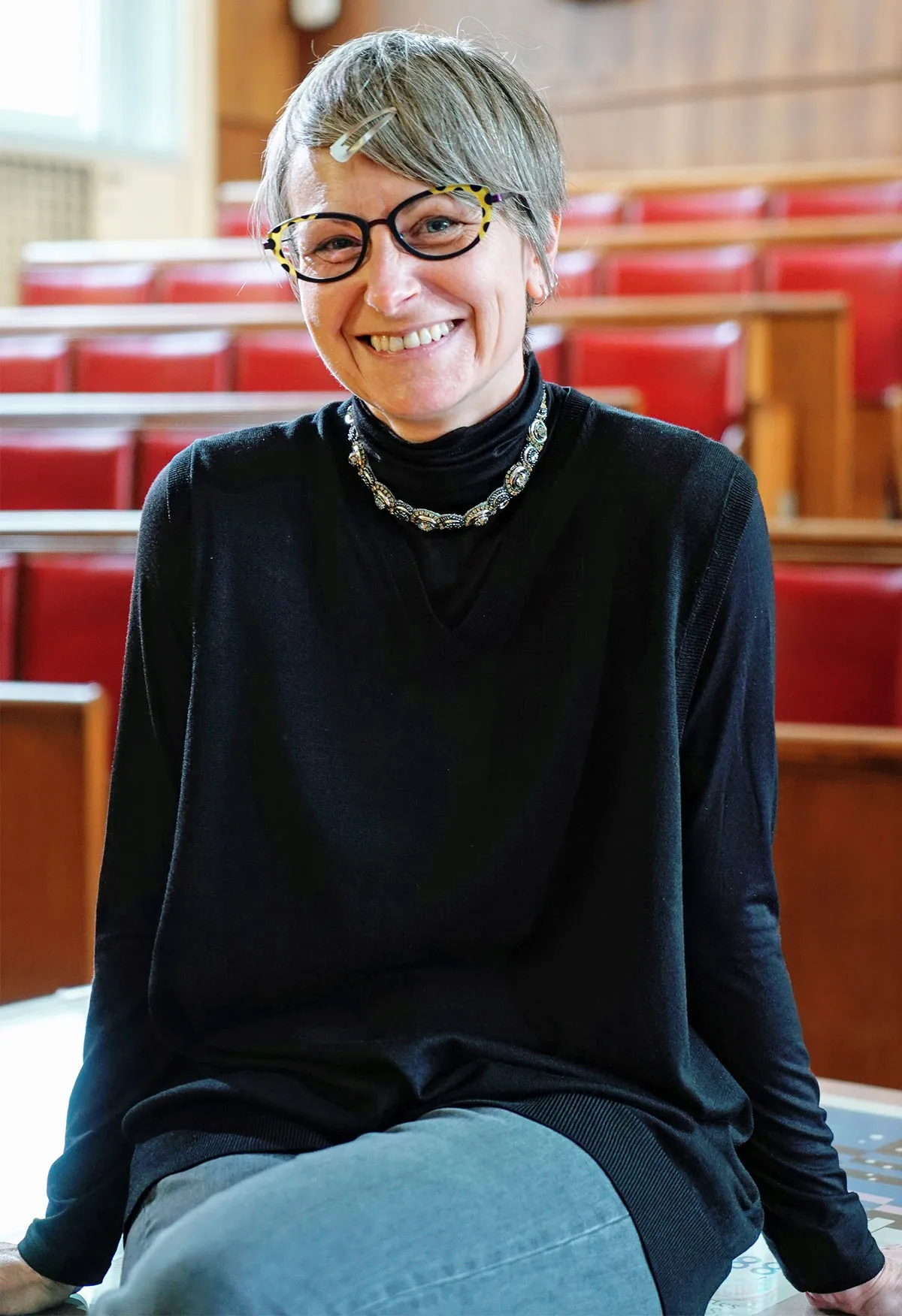 Volonteri is sitting in an auditorium, smiling at the camera. She’s wearing a black shirt.