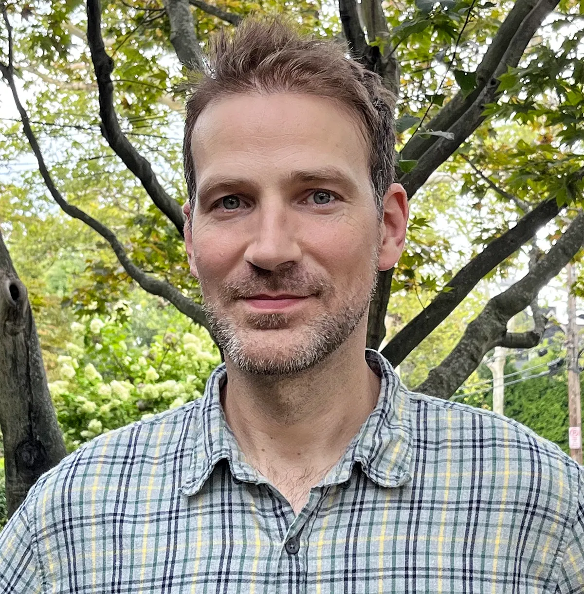 A headshot of Matthew Walker, with trees in the background.