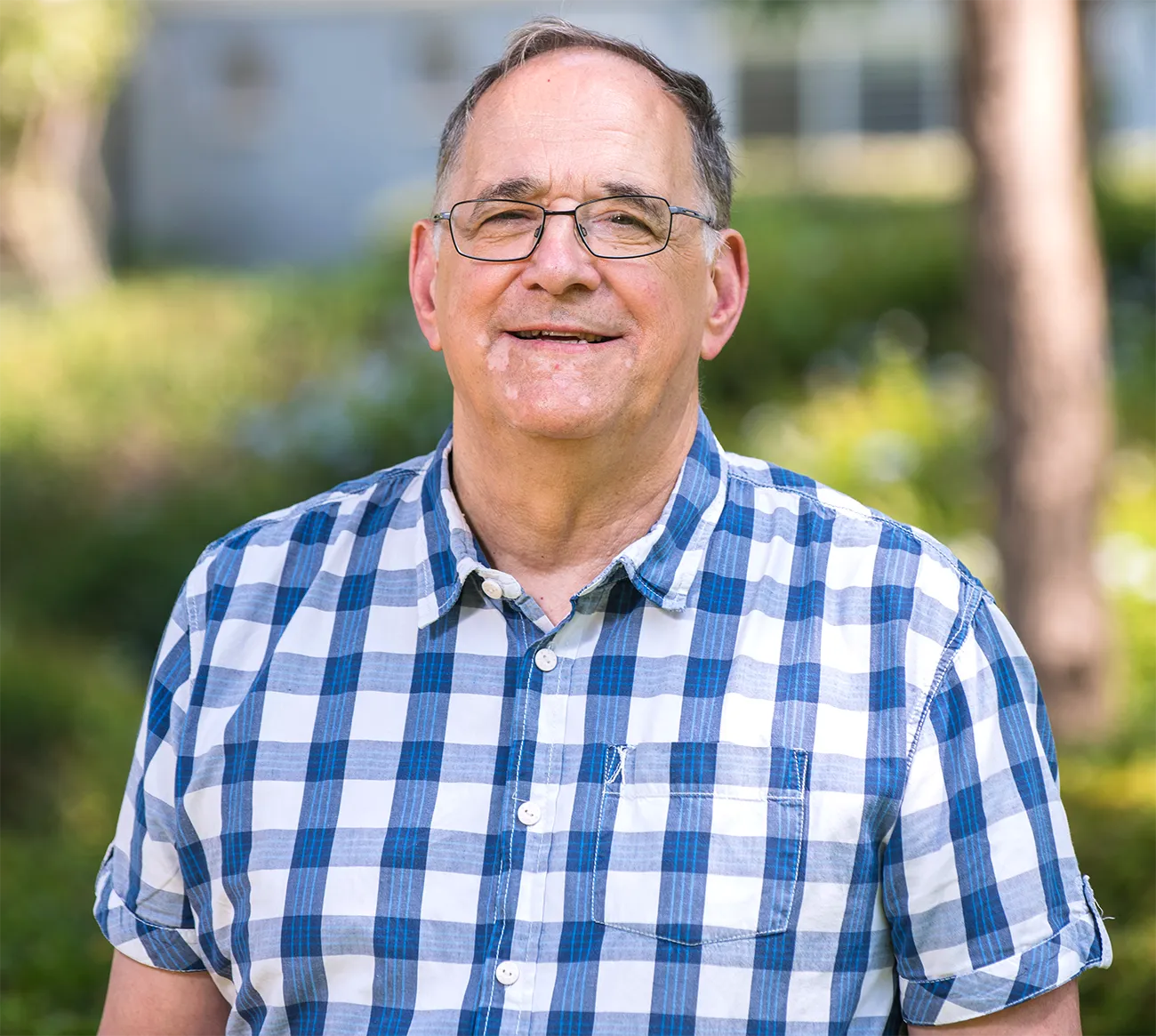 Headshot of Ron Naaman standing outside under trees.