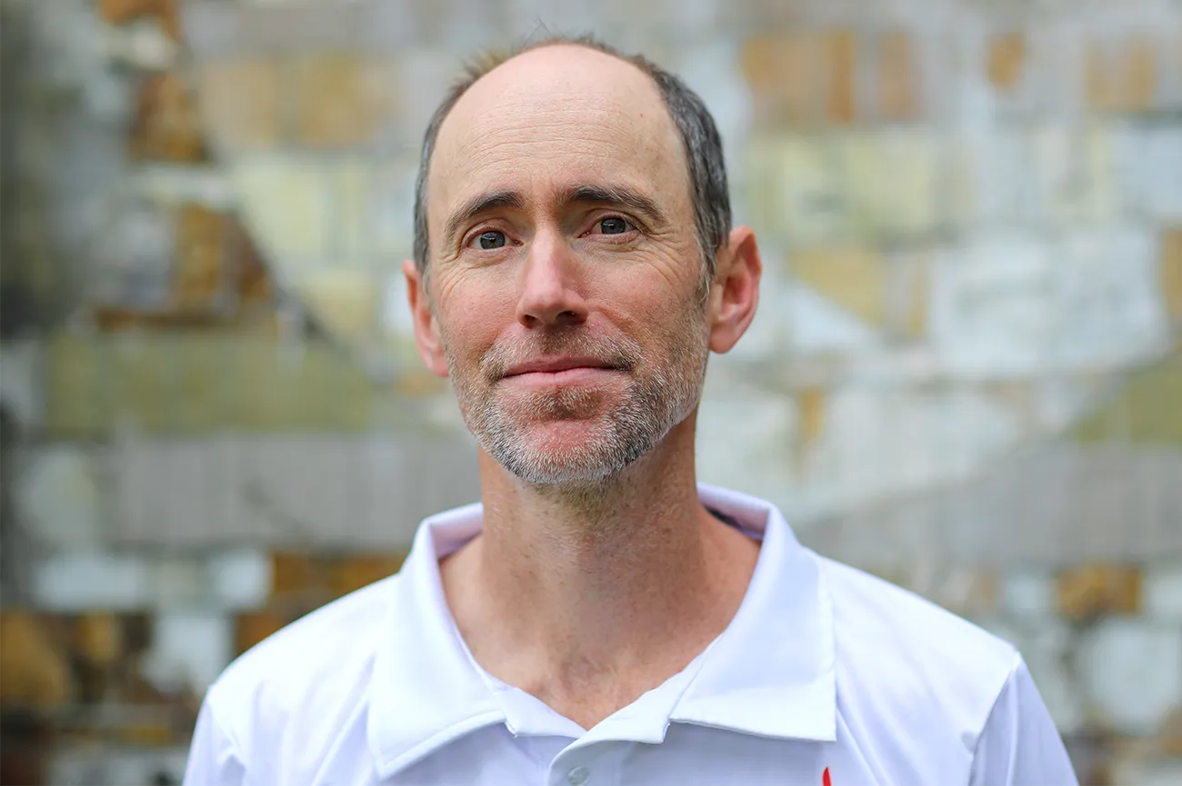 A portrait of Sean Raymond, who is looking at the camera with a small smile on his face.