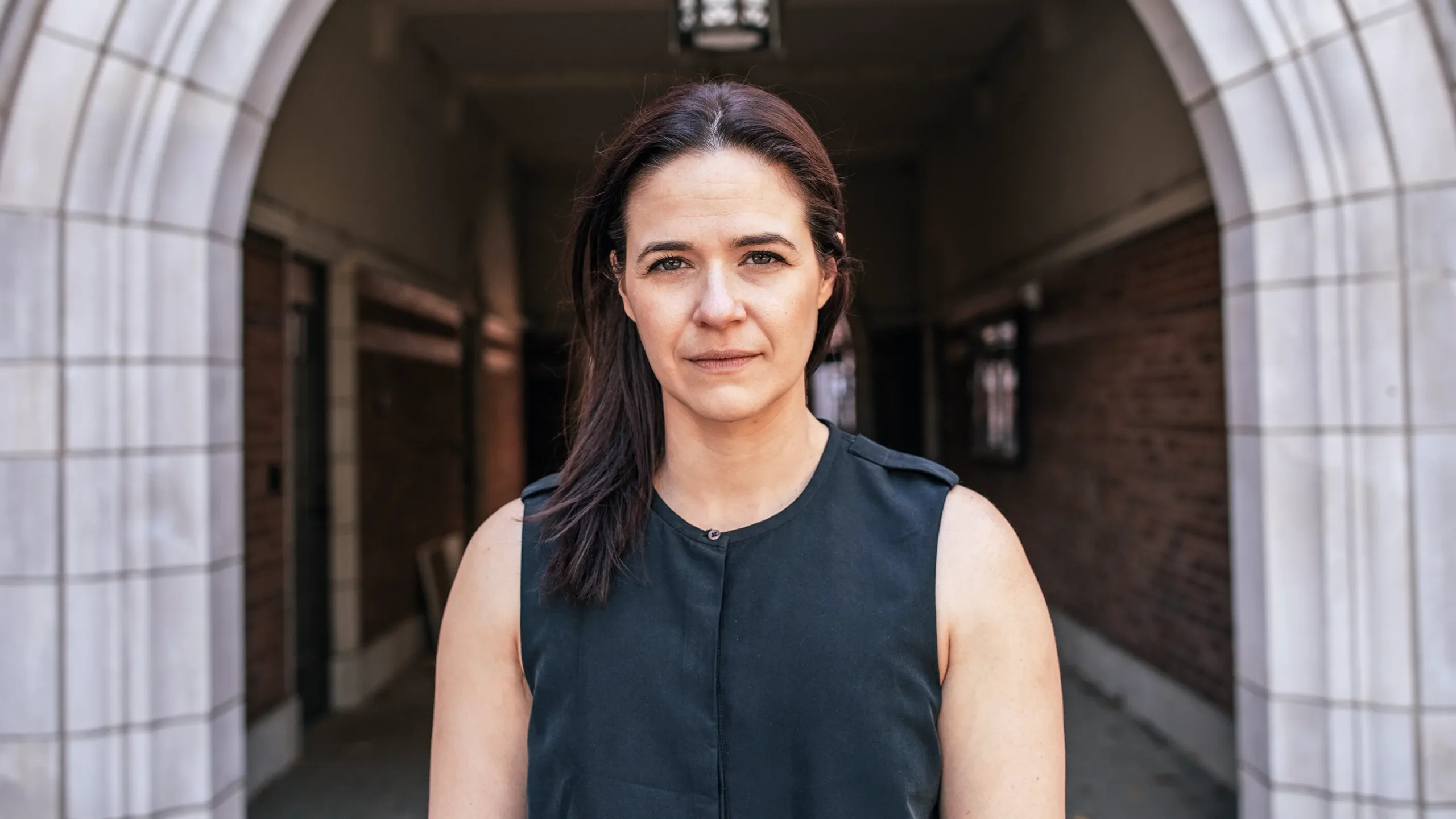 Erin Calipari stands in front of a concrete arch on the Vanderbilt University campus.