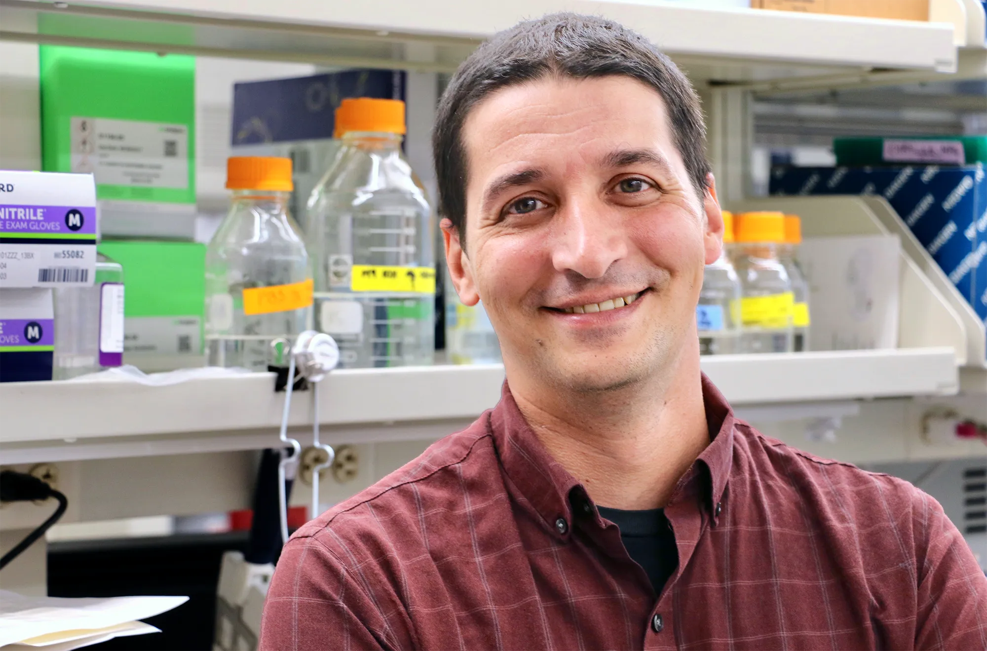 Alvaro Sanchez stands in front of a lab bench.