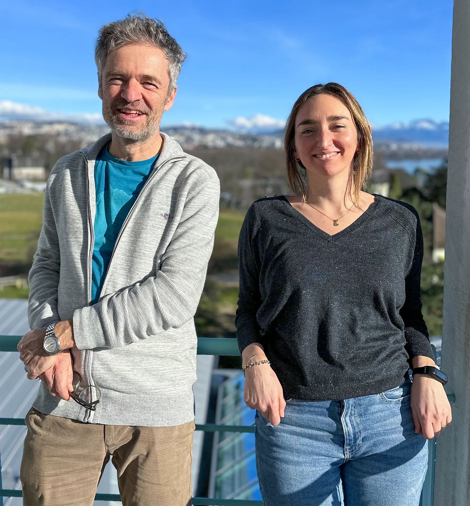 Christian Fankhauser and Martina Legris stand smiling outside in the sun.