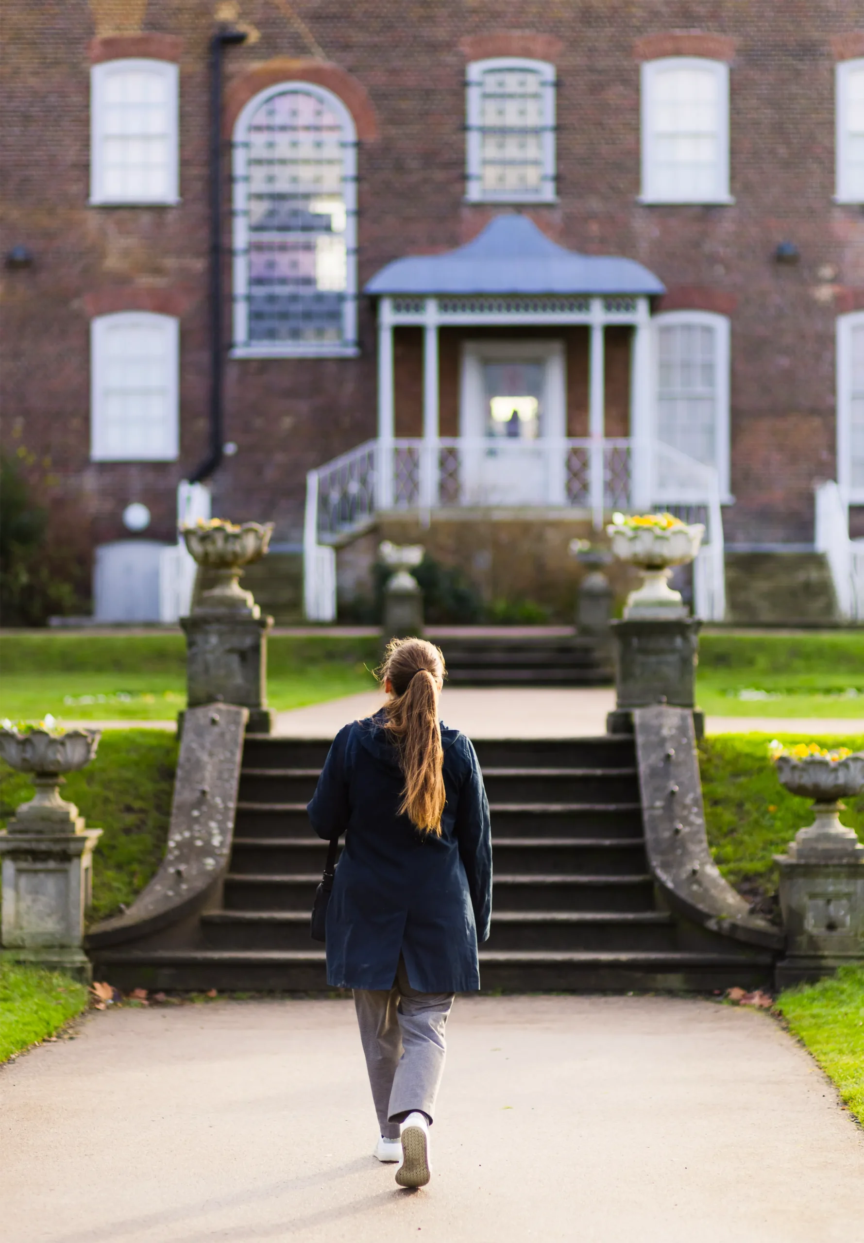 Mathematician Sarah Hart walking down a path towards stairs.