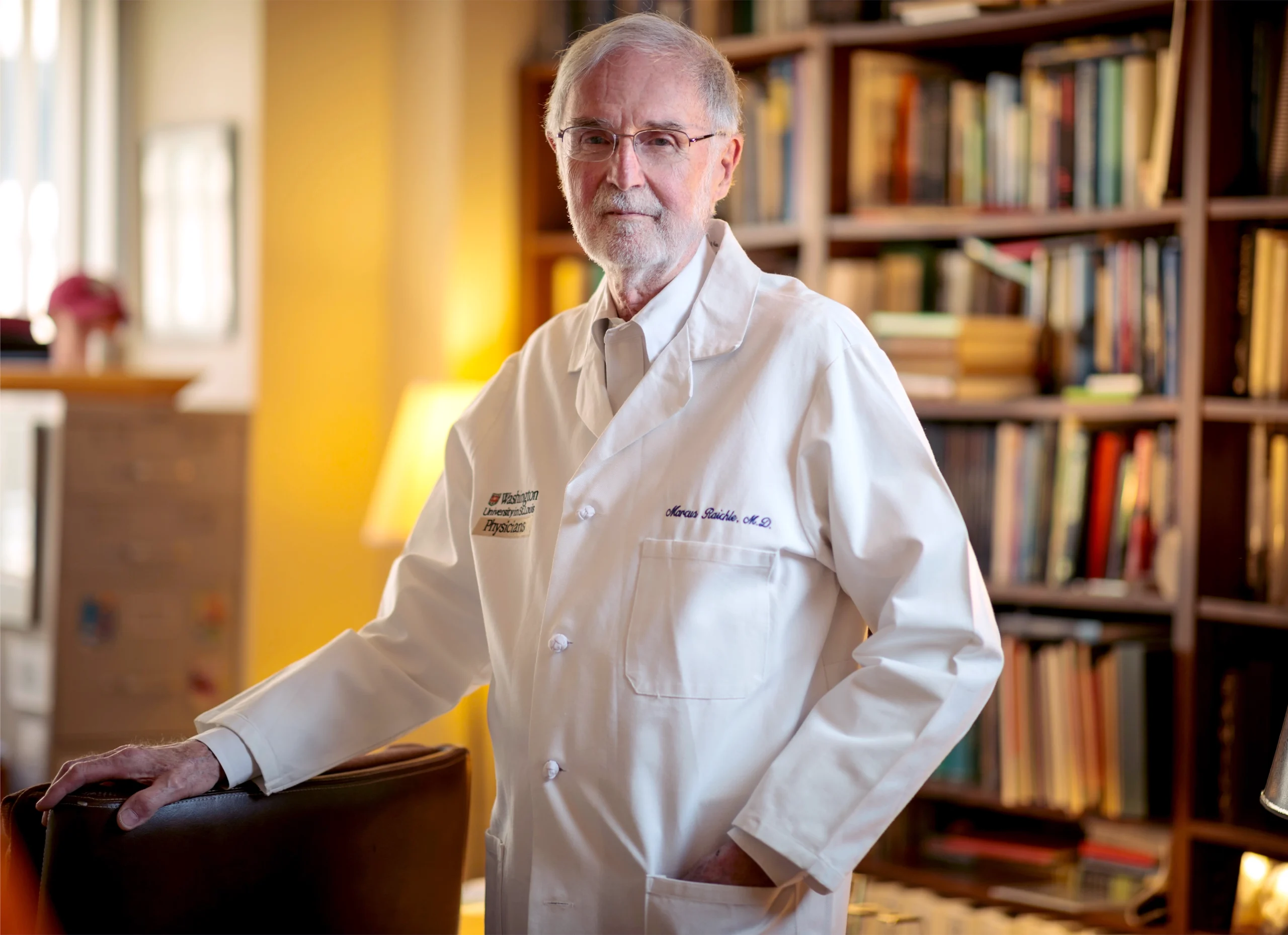 Marcus Raichle poses in his office wearing a white lab coat.