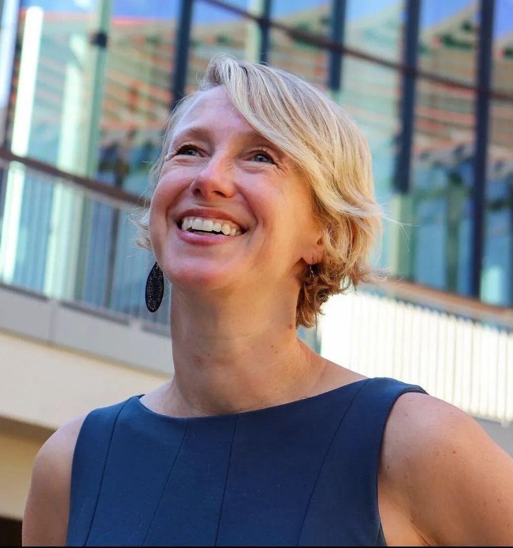 Portrait photo of researcher Polly Fordyce of Stanford University, outside a building, looking up.