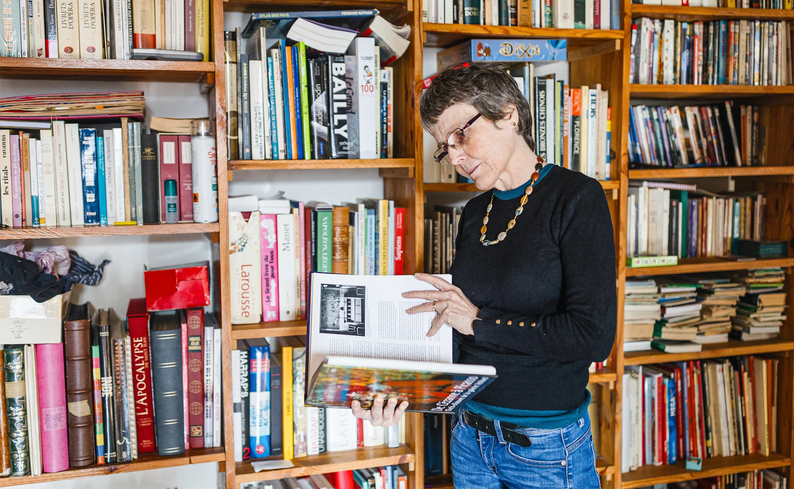 A portrait of Claire Voisin in front of bookshelves.