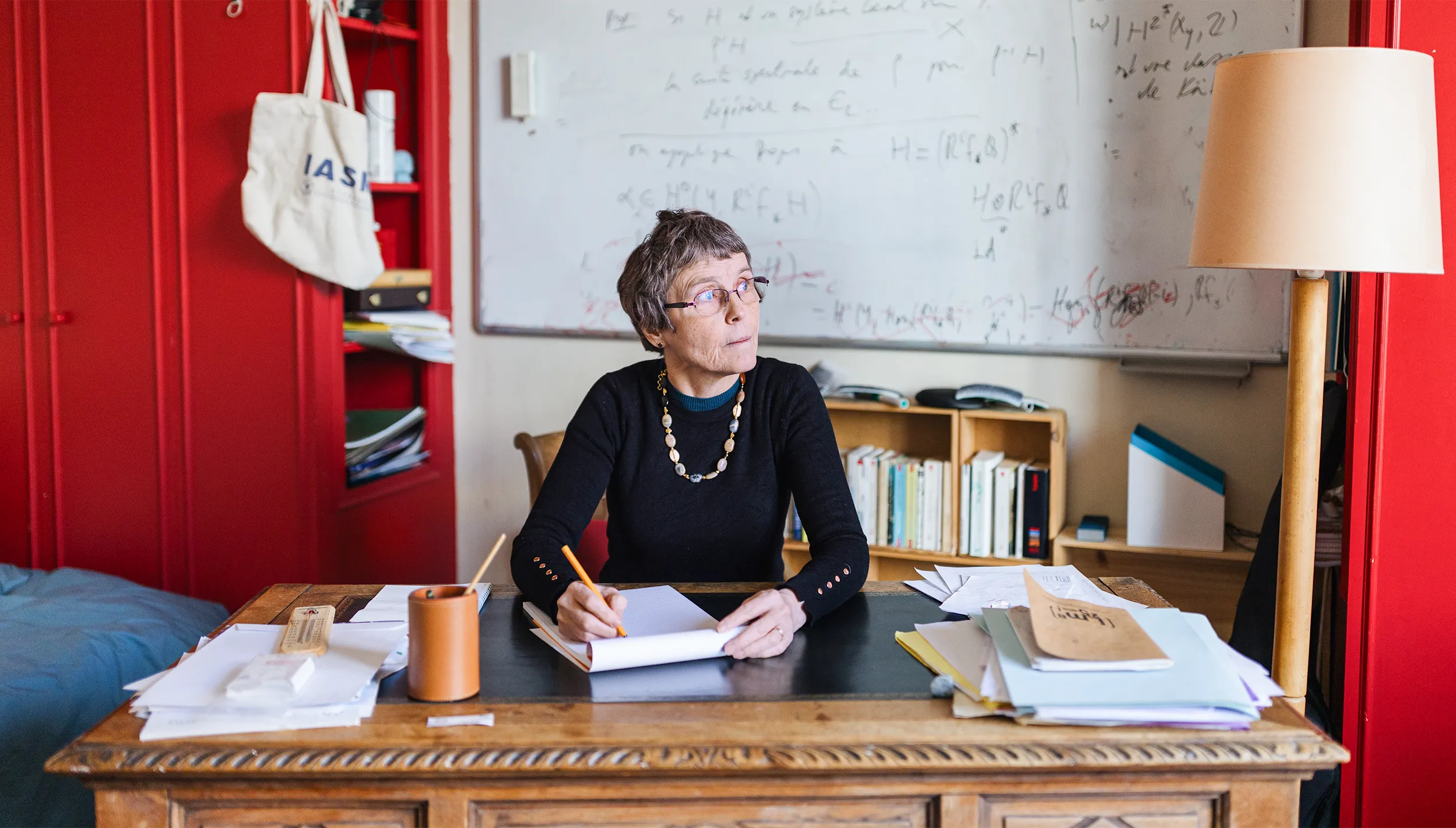 A portrait of Claire Voisin working at a desk.