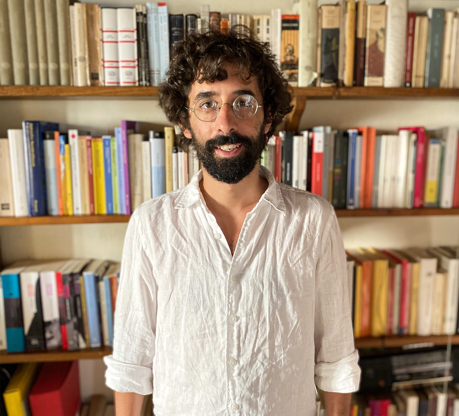 A portrait of Giacomo Novembre standing in front of a bookcase.