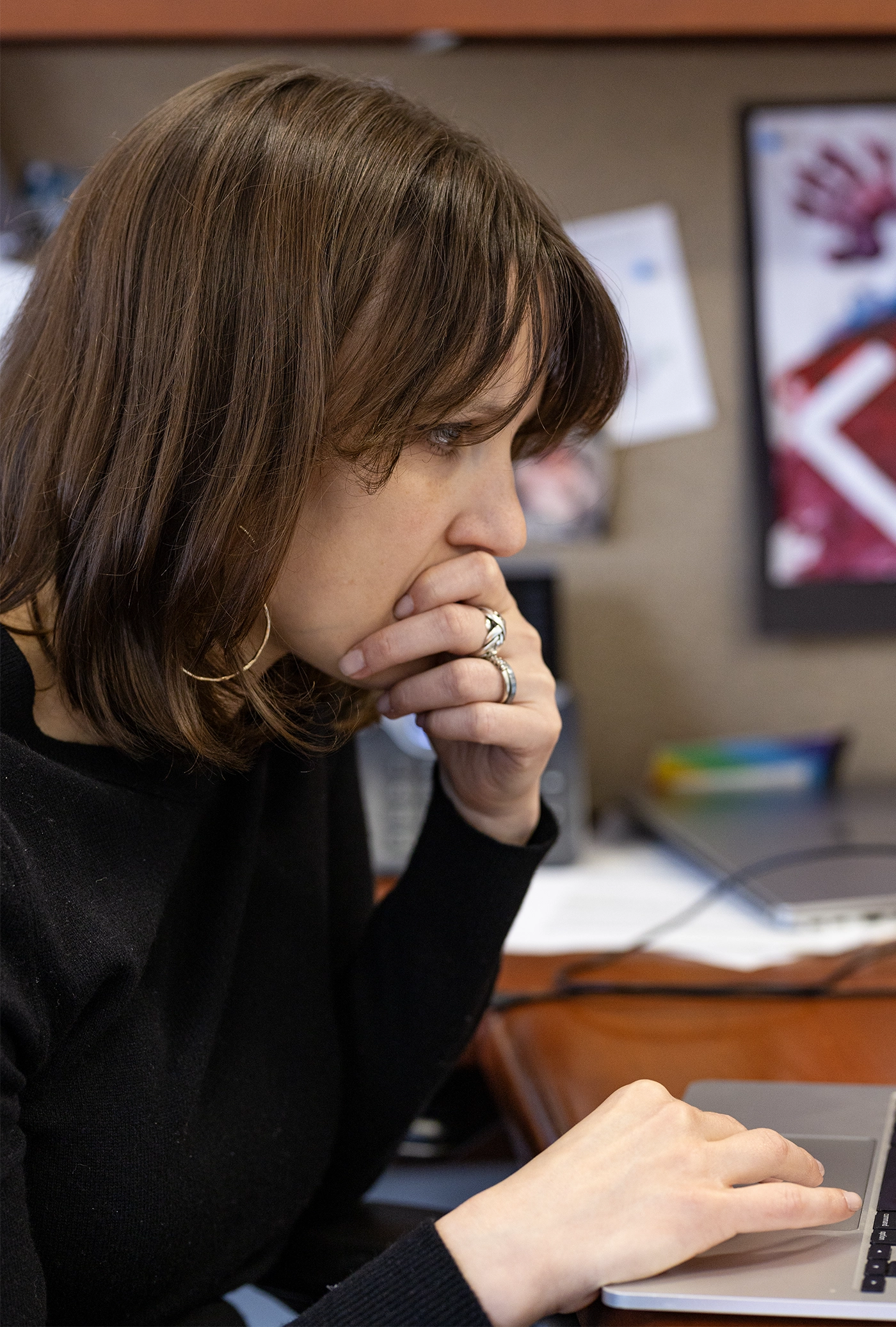 Ellie Pavlick in a black shirt sits at a laptop deep in thought