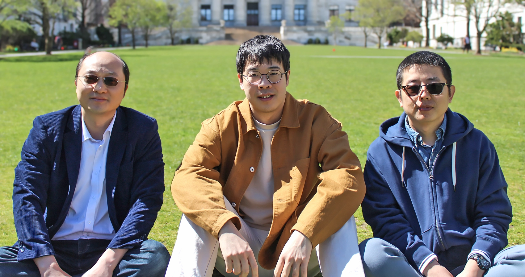 Yang-Yu Liu, Zheng Sun and Xu-Wen Wang stand in front of a Harvard sign.