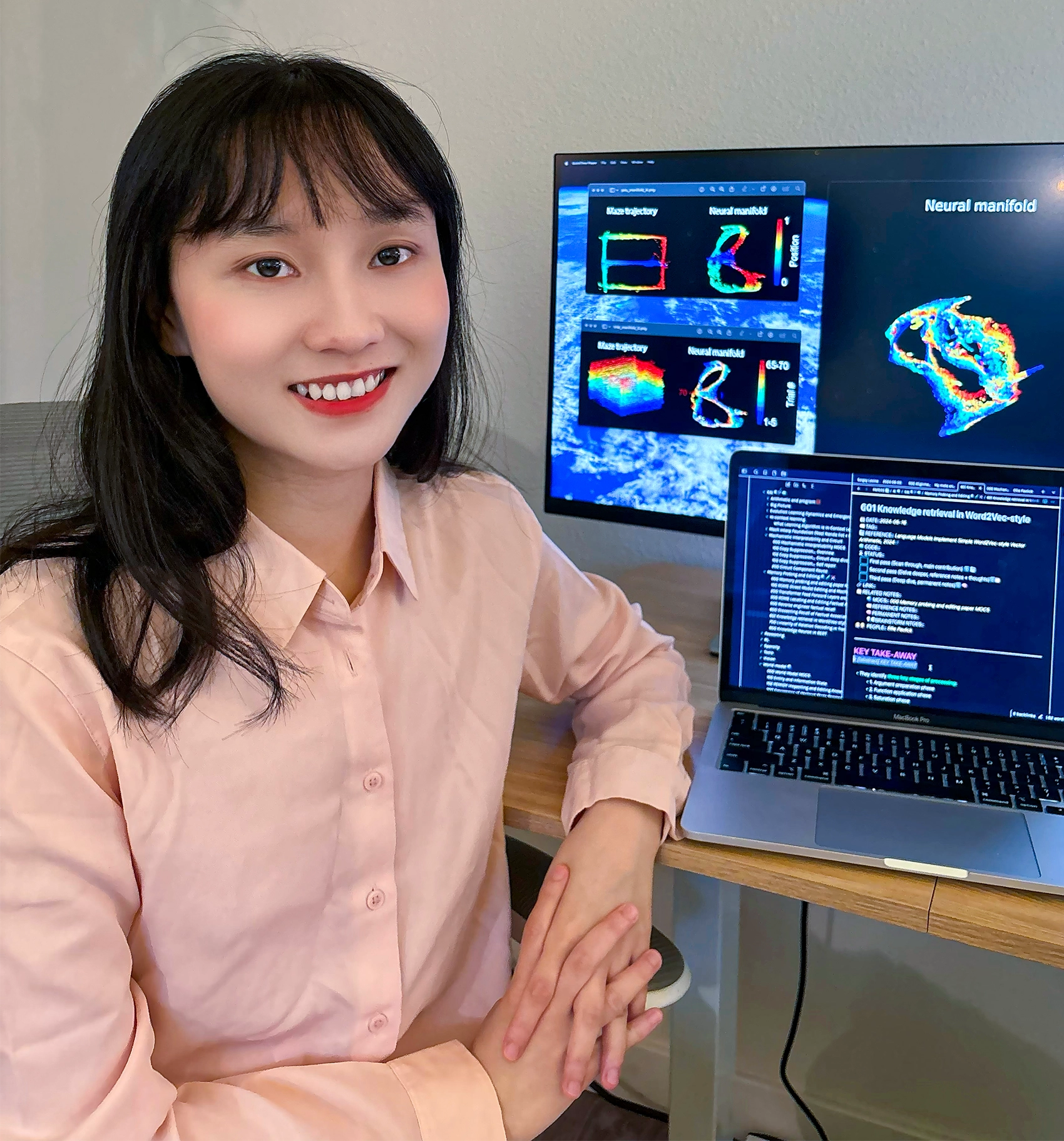 Wannan Yang sits next to a computer displaying her data.