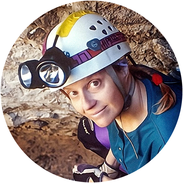 A woman with a helmet and headlamp