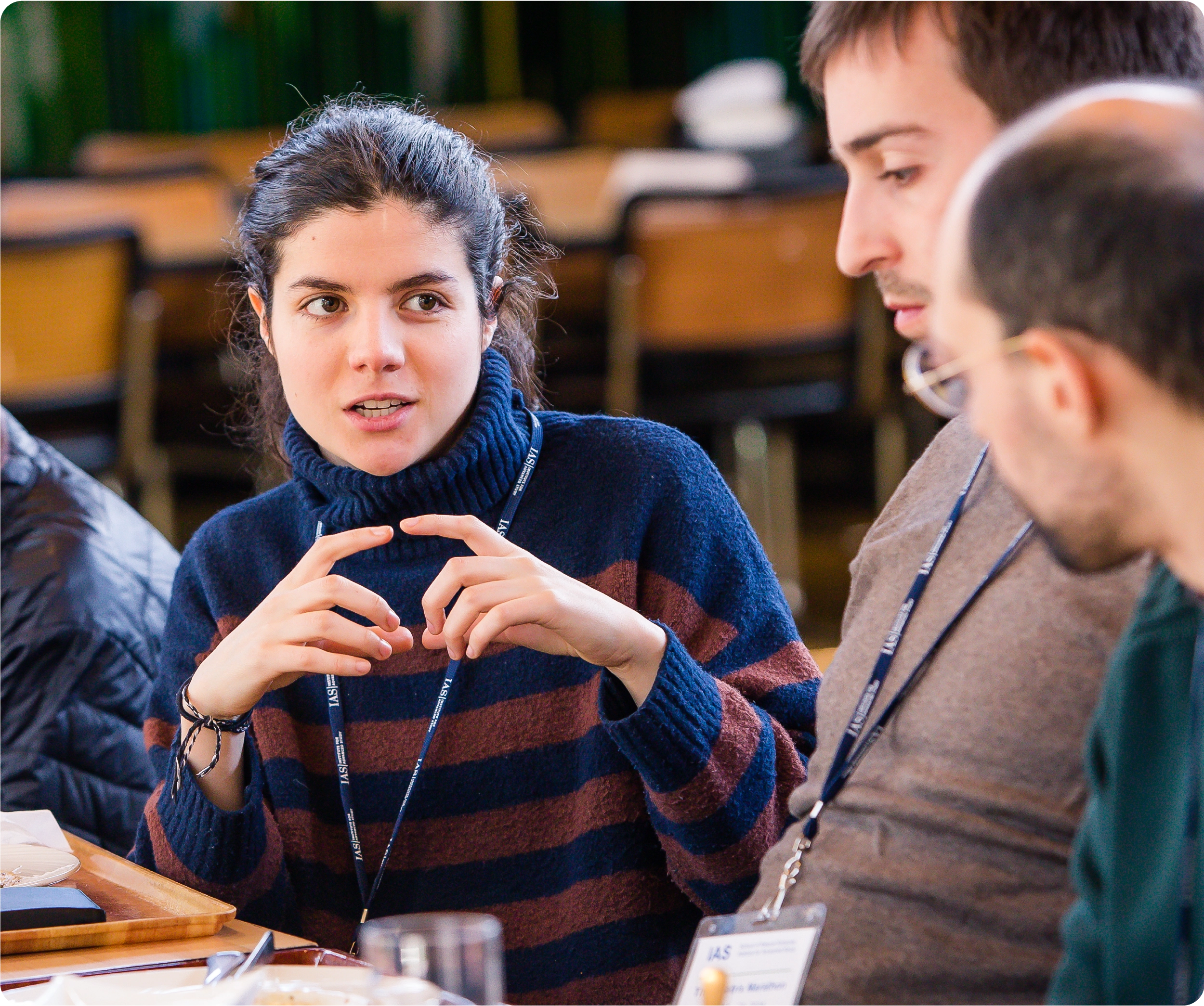 A woman has a conversation with two men over a meal.