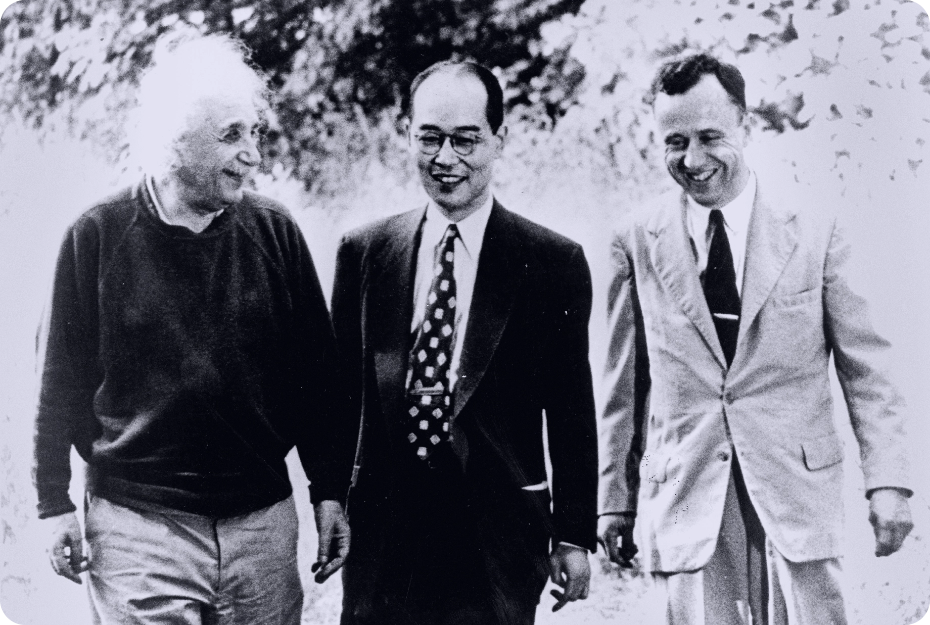 Black and white photo of three men walking and talking.