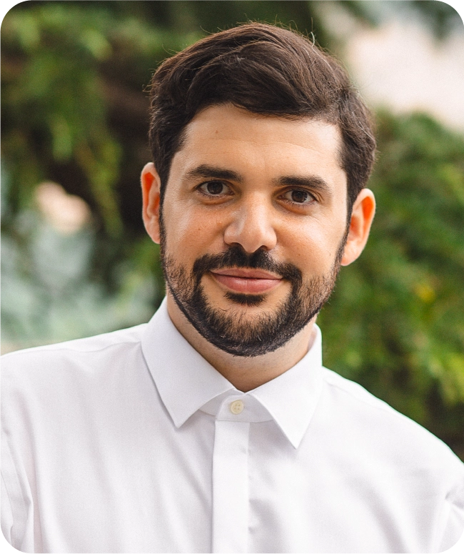 A bearded man wearing a white shirt.