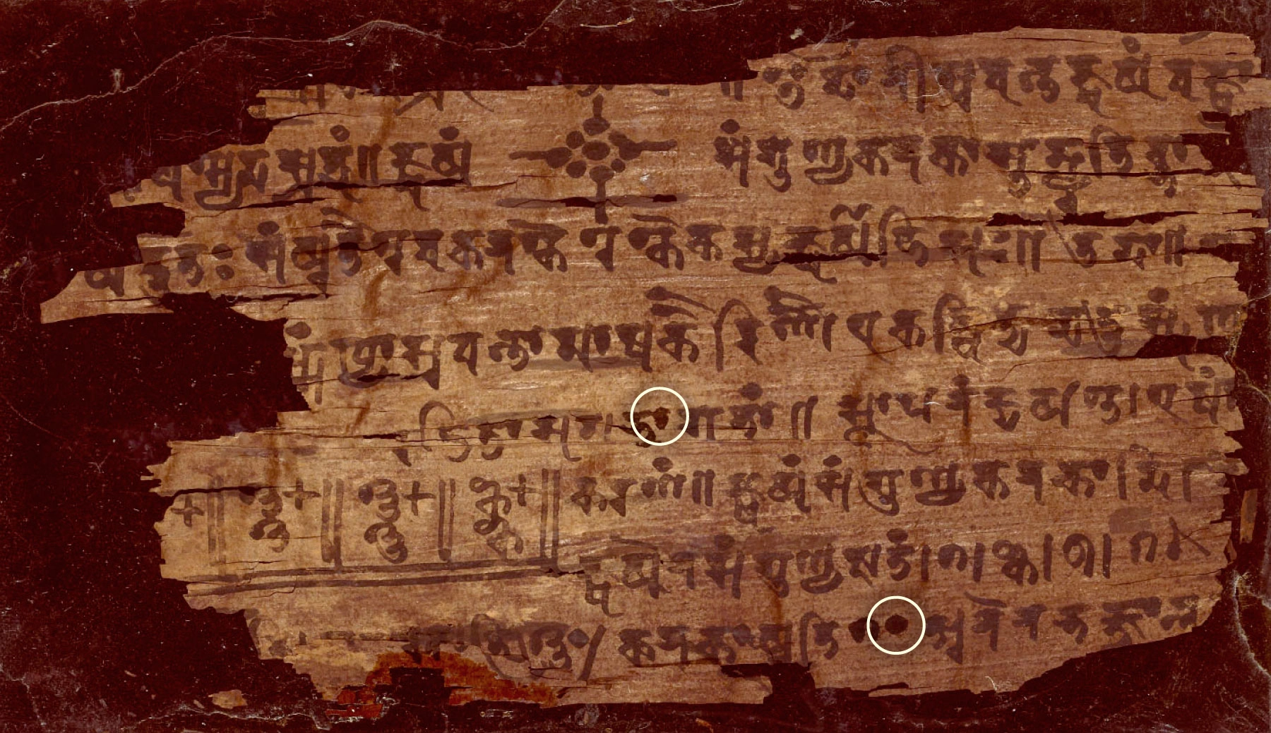 A filled-in dot is part of an ink-scrawled Sanskrit text.