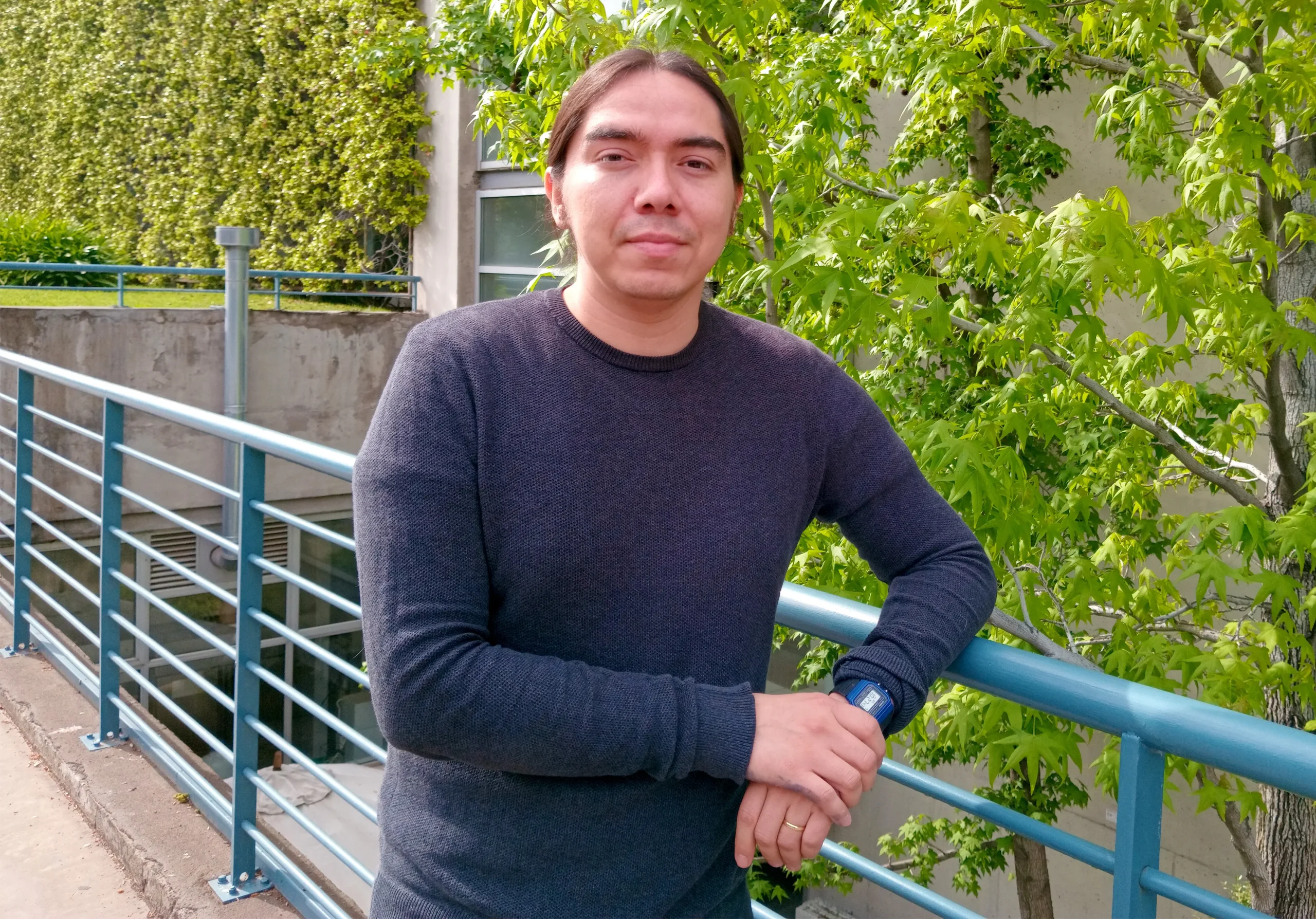 A mathematician standing in front of some trees.