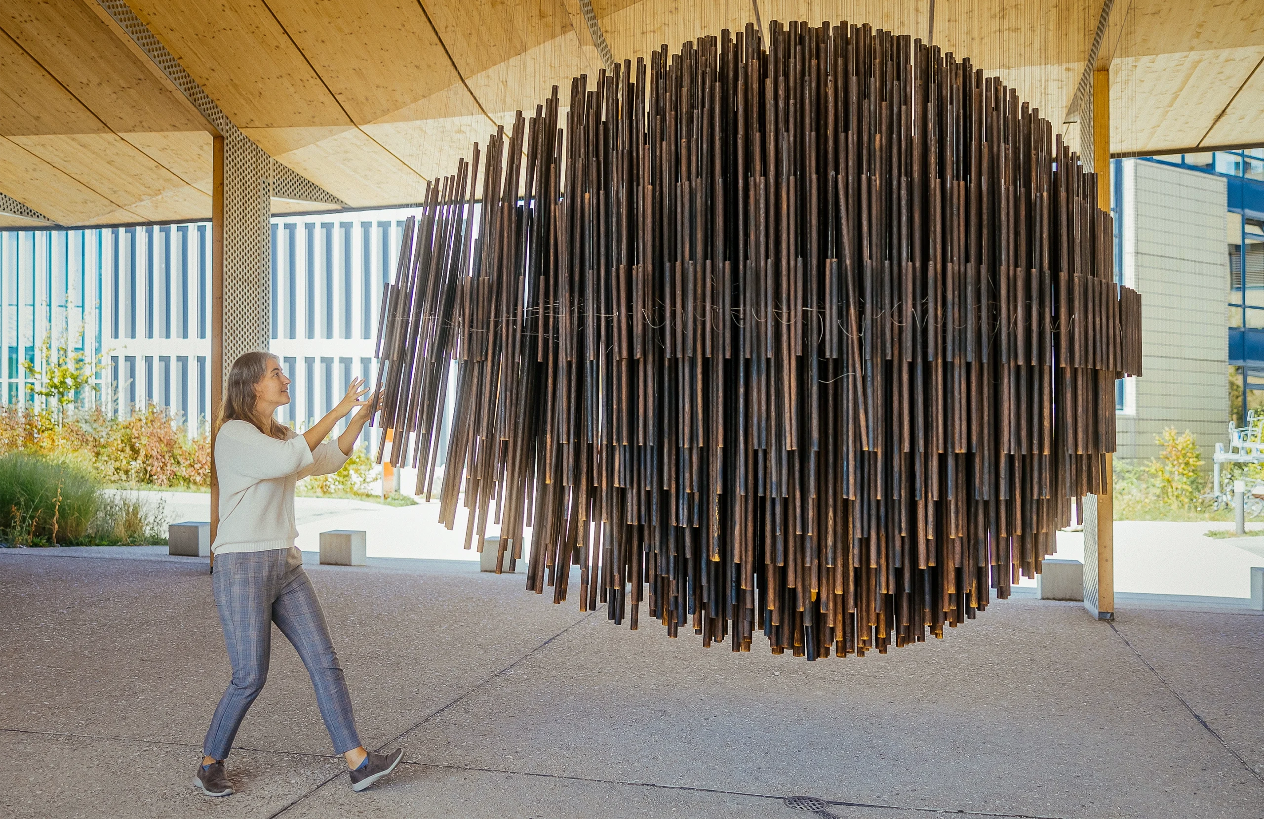 Lenka Zdeborová pulls on pieces of a giant sculpture made of metal rods