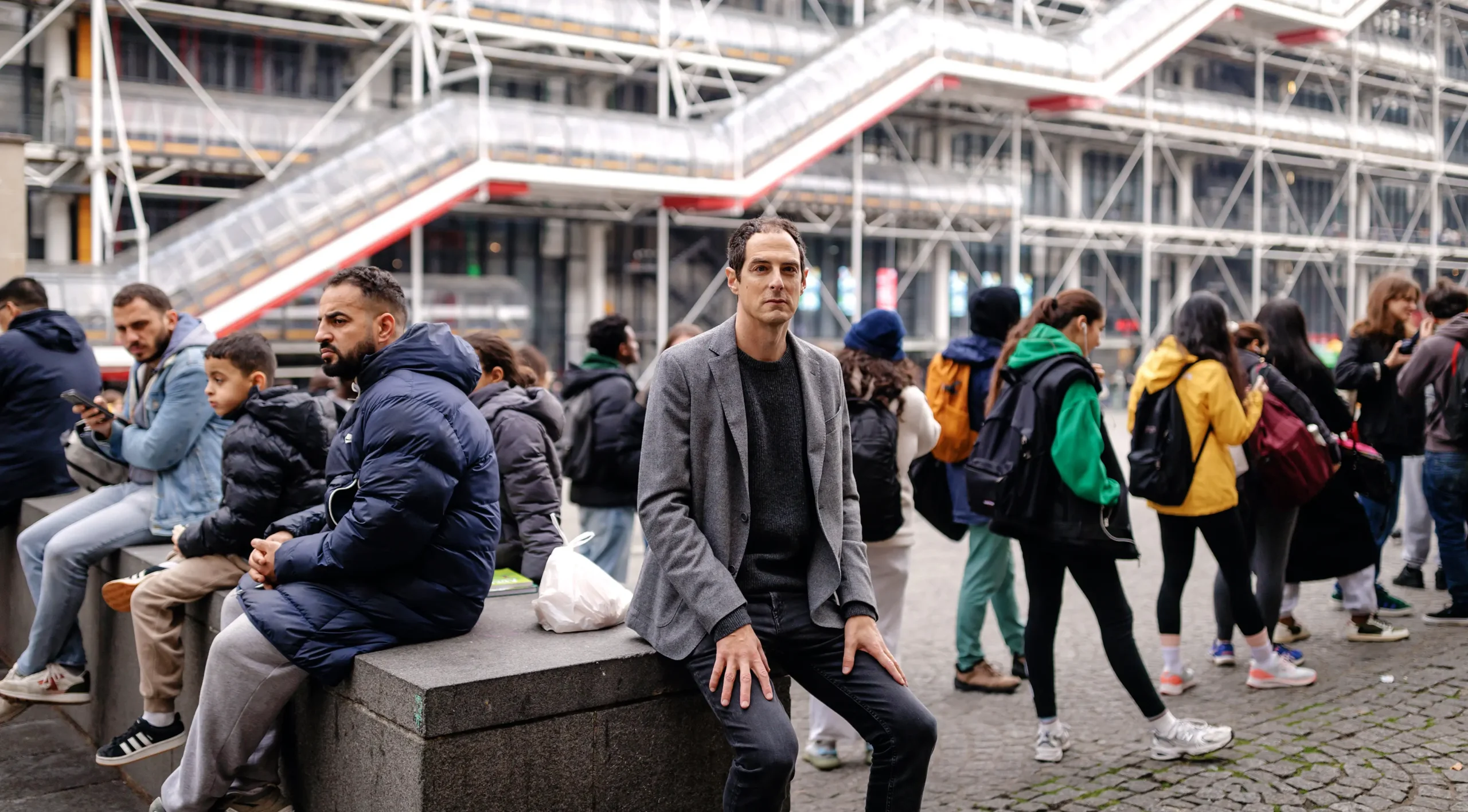 Bessis sitting in front of the Centre Pompidou in Paris.