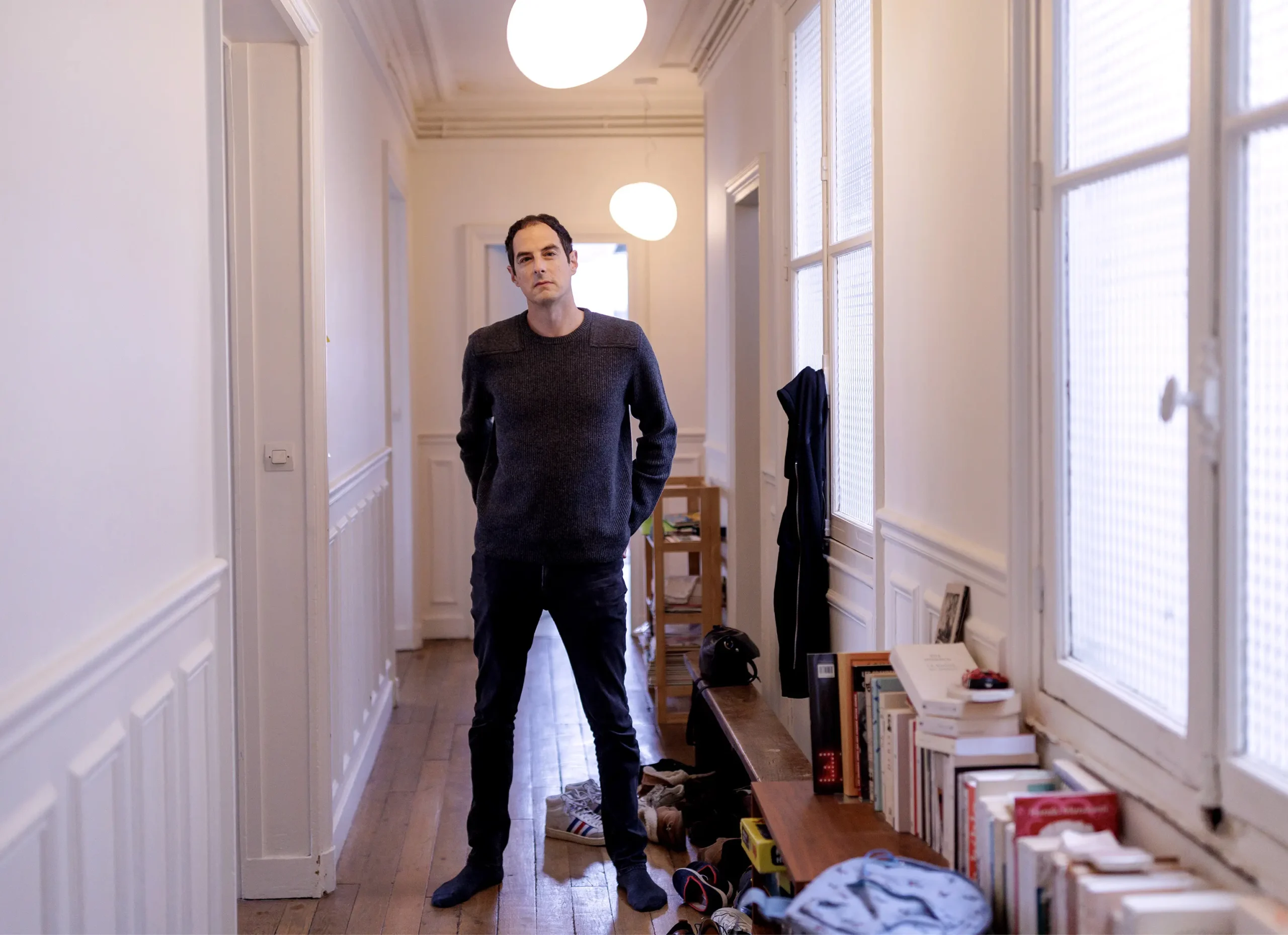 Bessis standing in the hallway of his Paris apartment.