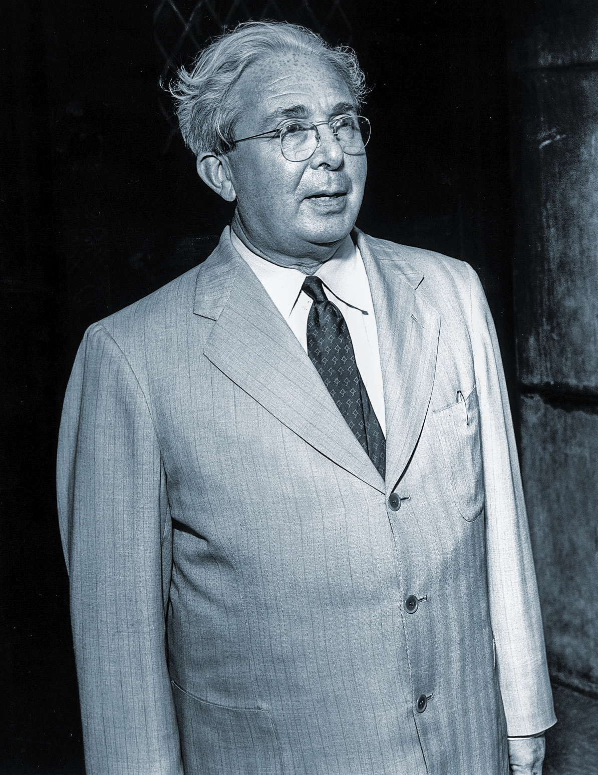 Black-and-white candid photo of a man in a suit.