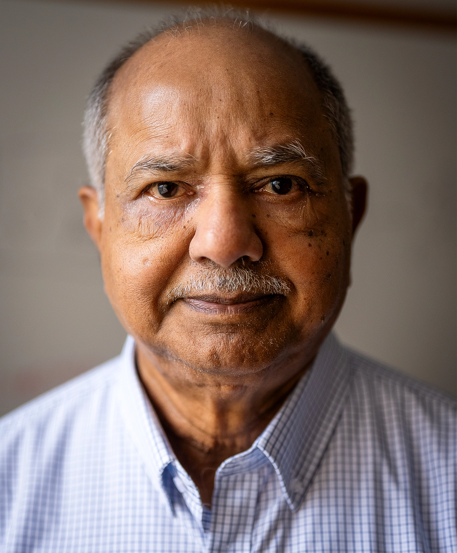 Close-up photo of Raj Reddy in a checkered shirt.