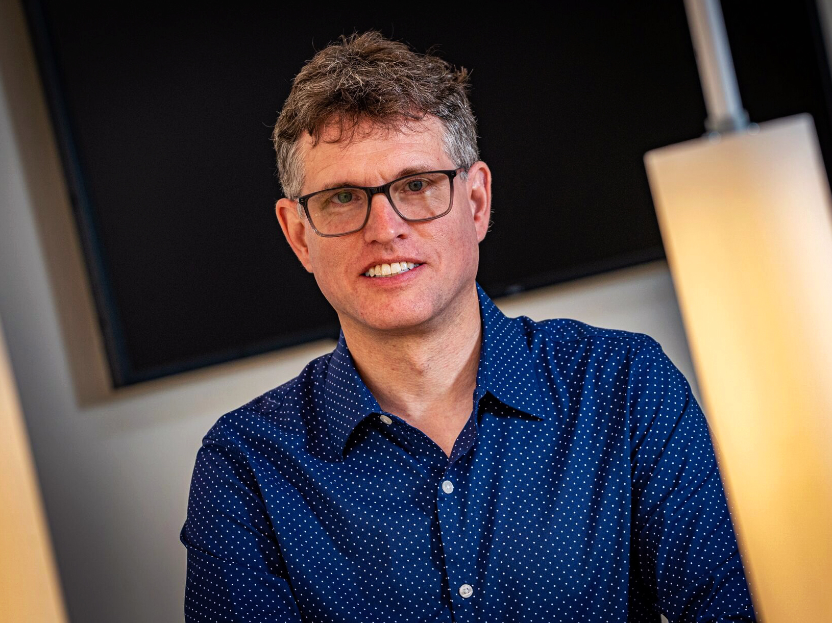 Michael Bender in a blue shirt wearing black glasses.