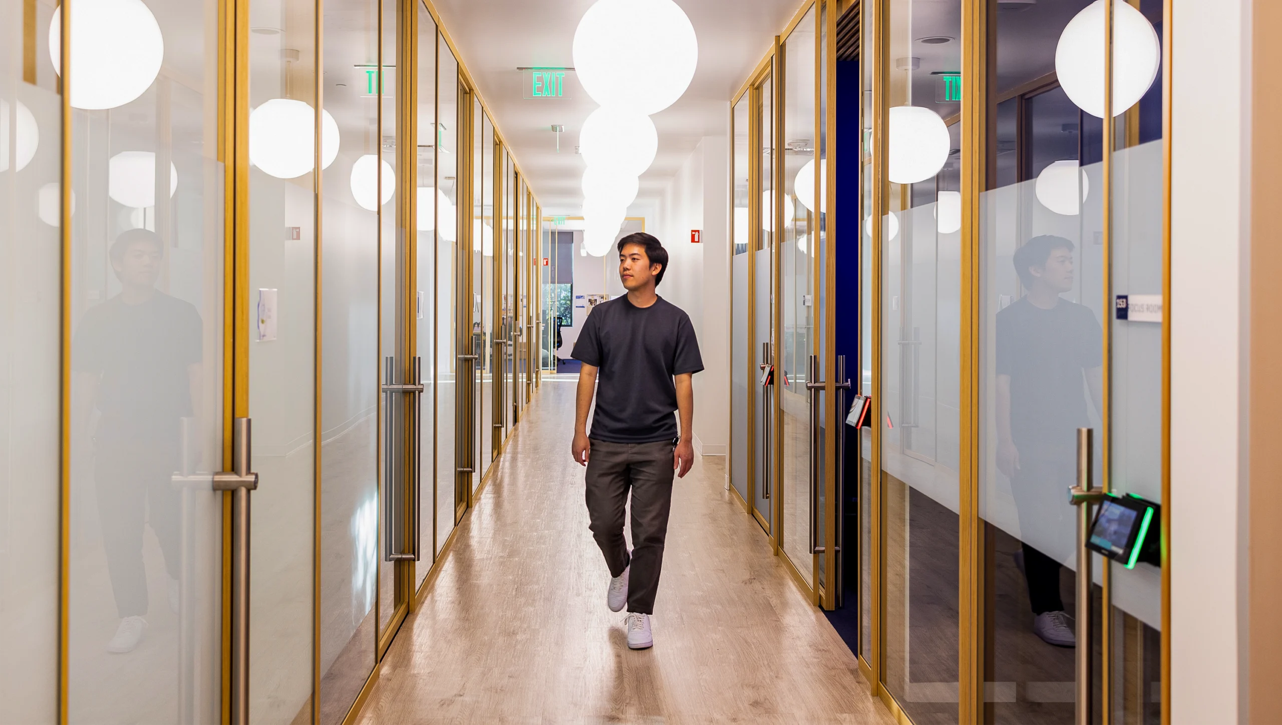 Brian Hie walks down a hallway.