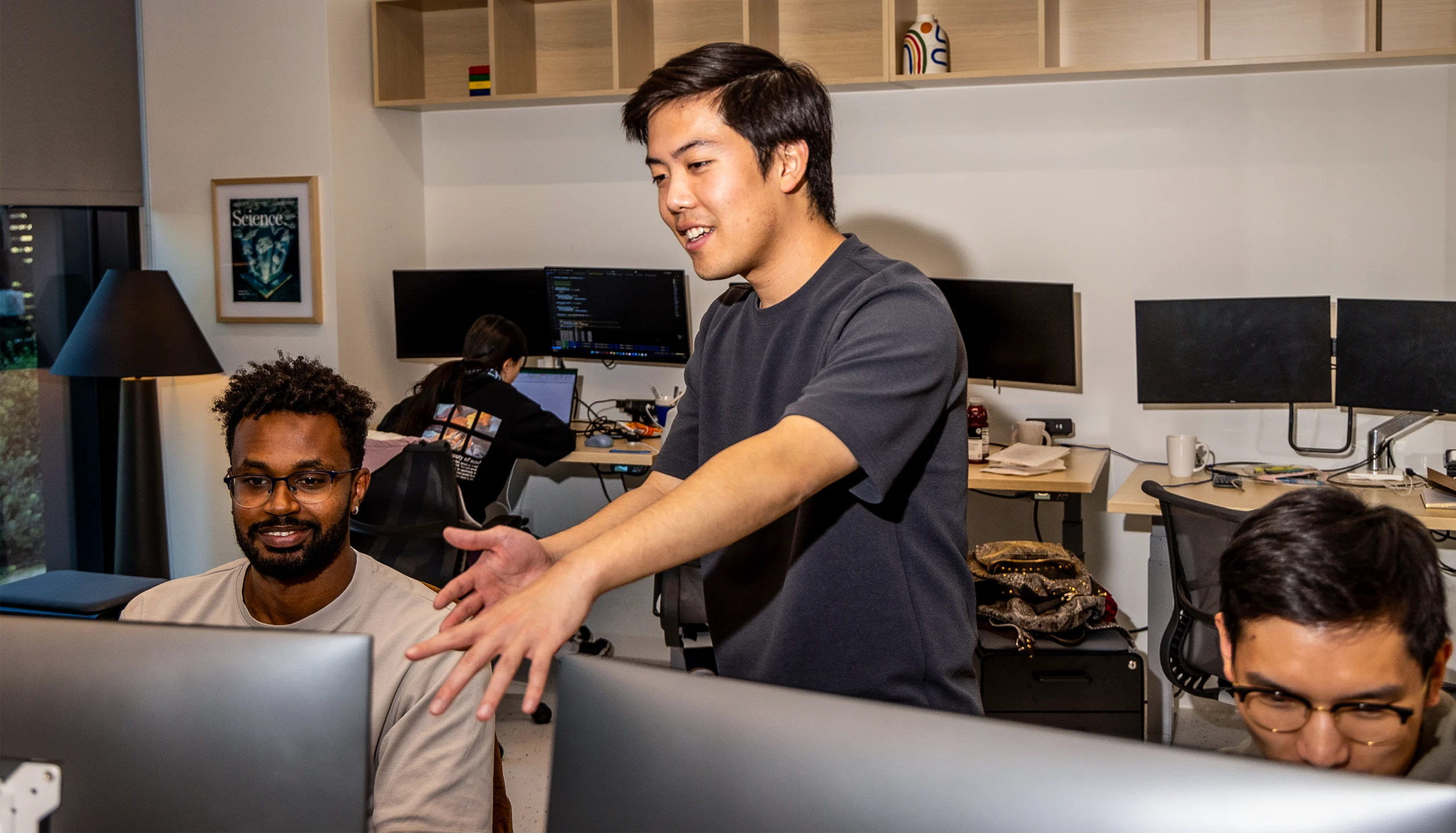 Brian Hie talks to his students, who are working at computers.