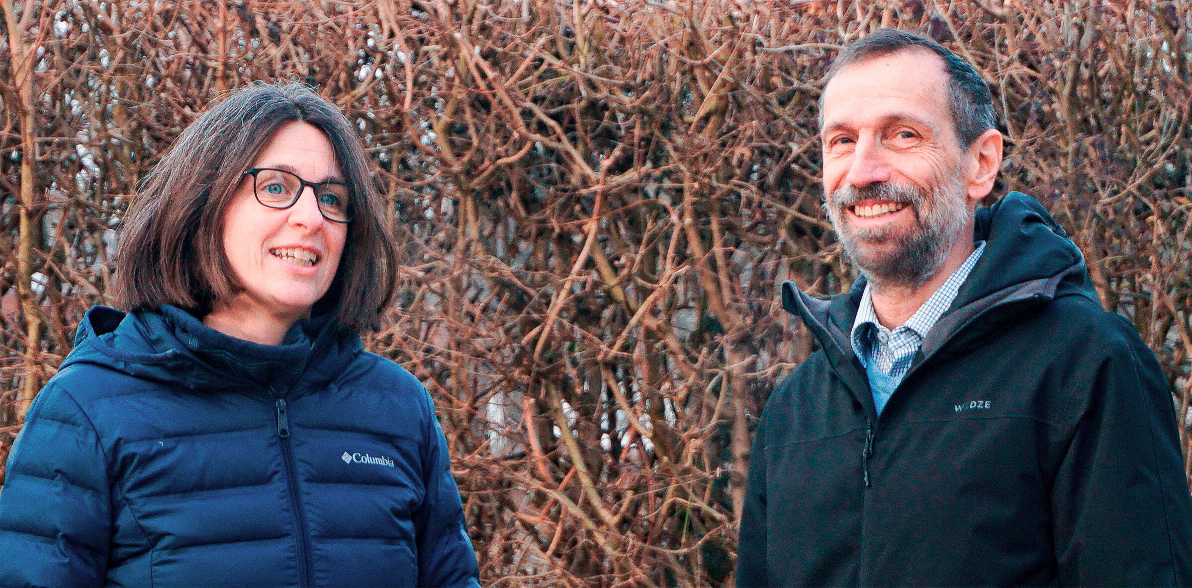 A man and a woman standing next to each other, both of them smiling