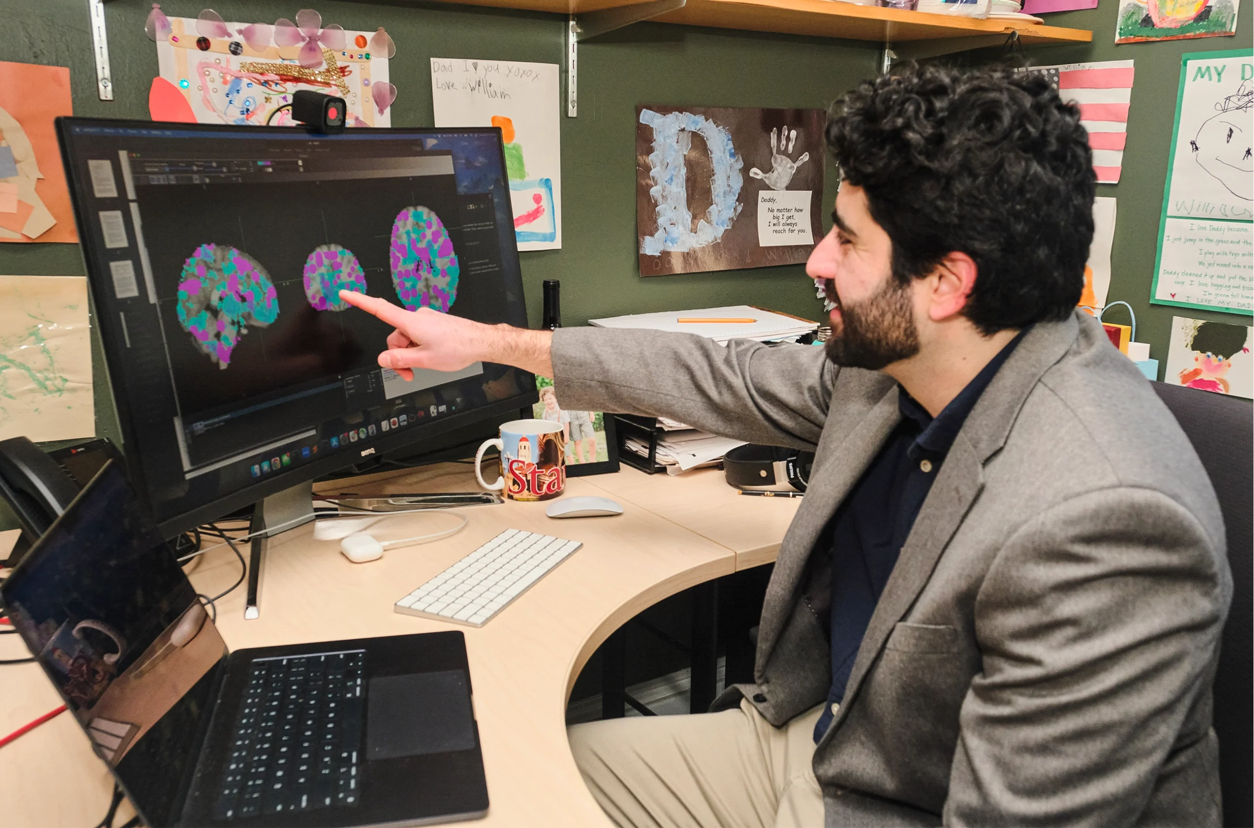 Christopher Baldassano points at brain data on his computer screen.