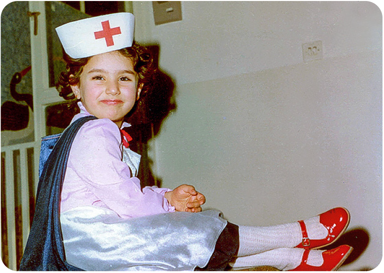 Child wearing a nurse’s cap.