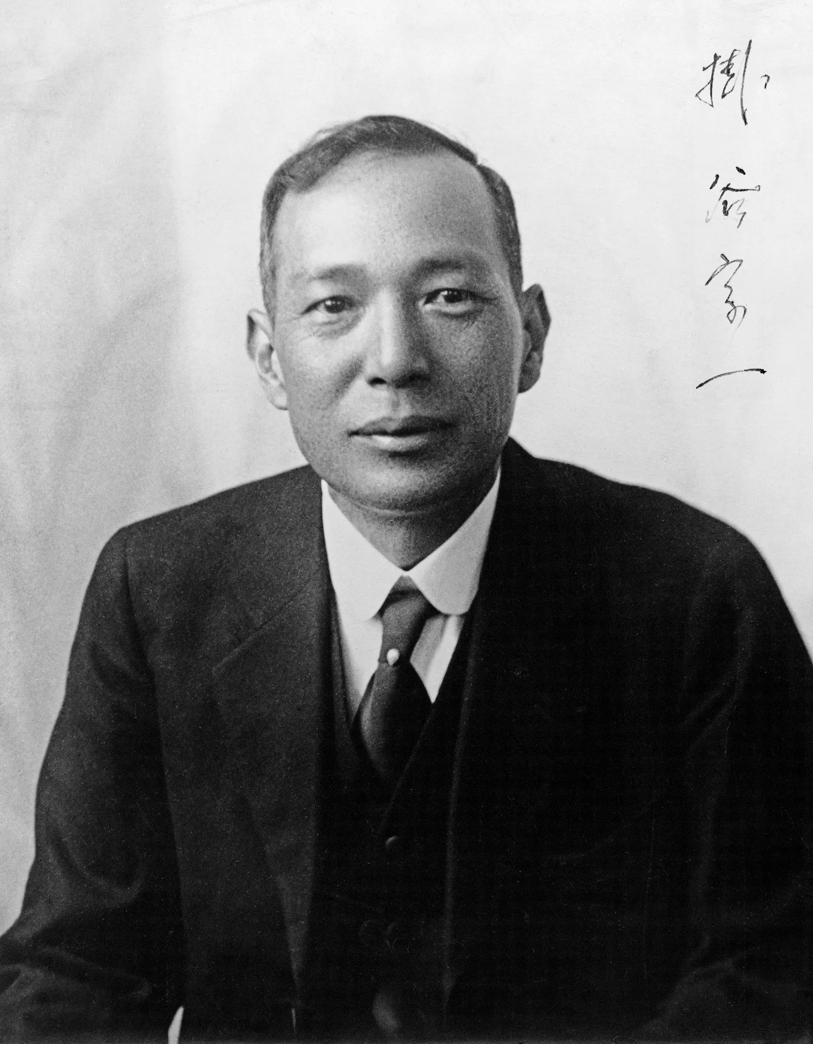 A black and white photo of a man in a suit.