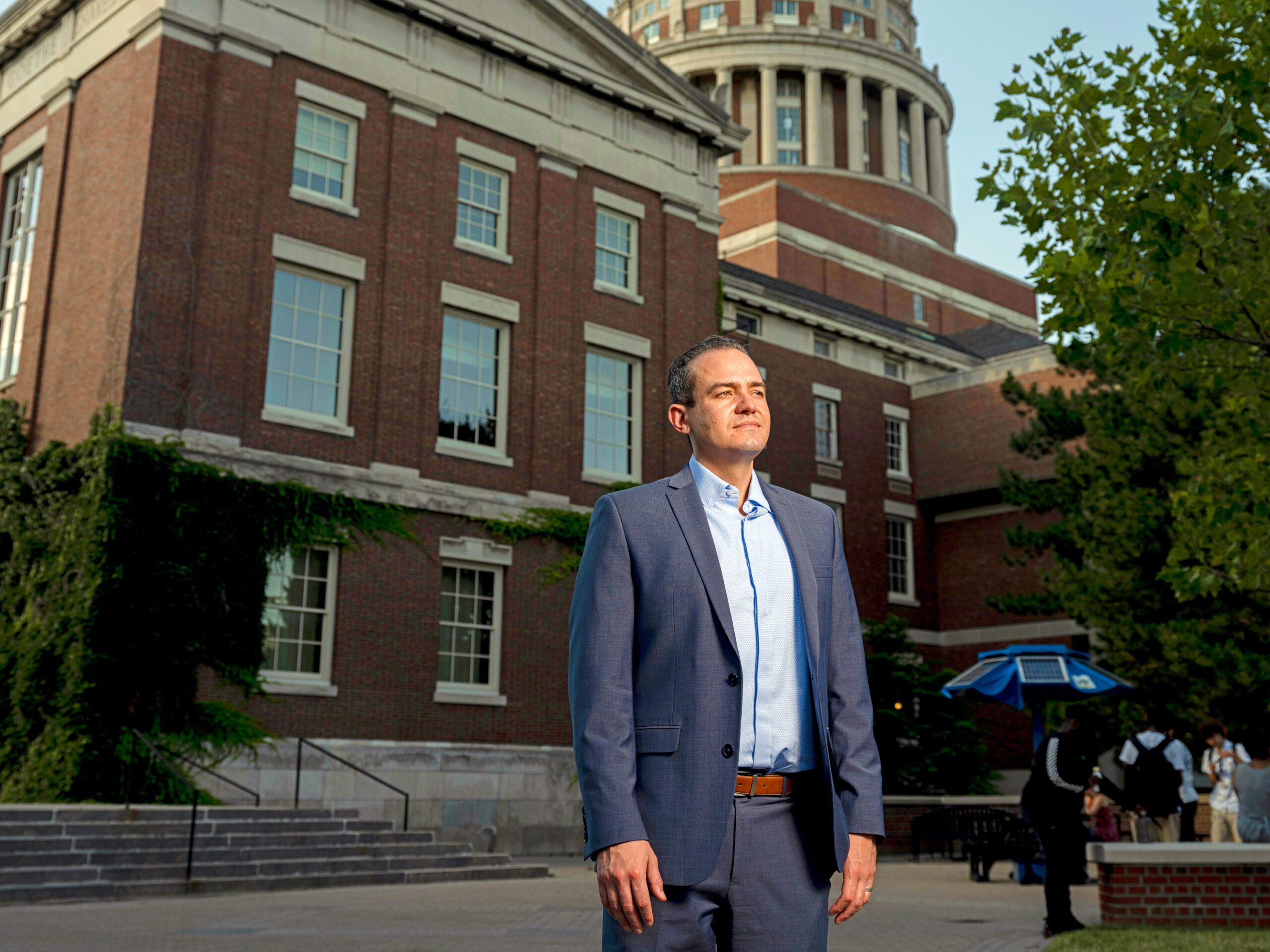 A man in front of a brick building.